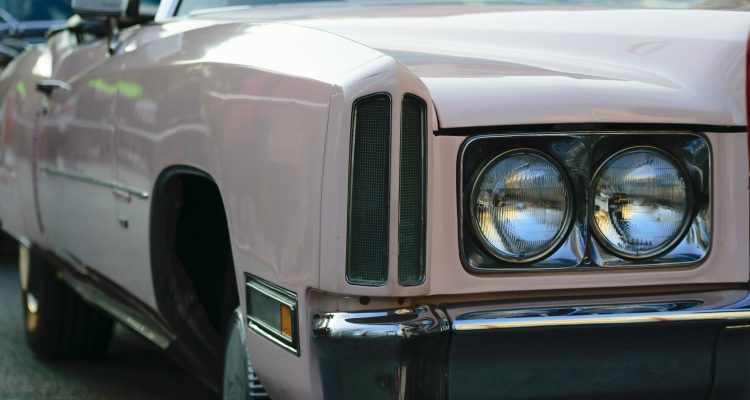 Closeup shot of the headlights of a beige antique car